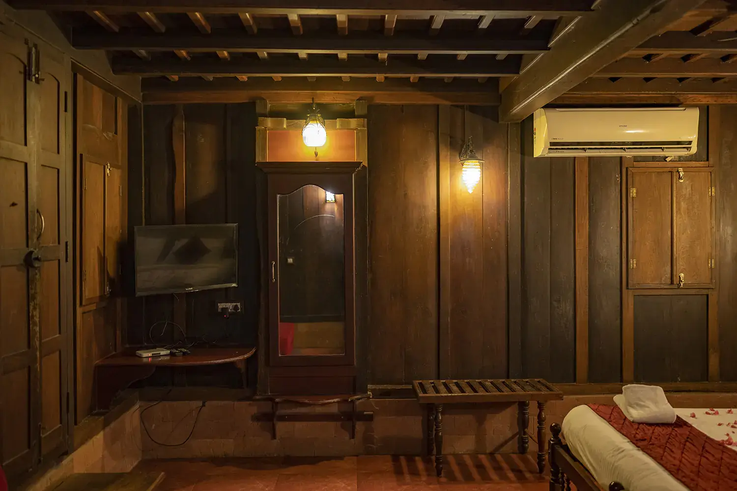 Carved wooden wardrobe and timber ceiling in the Deluxe Heritage Room