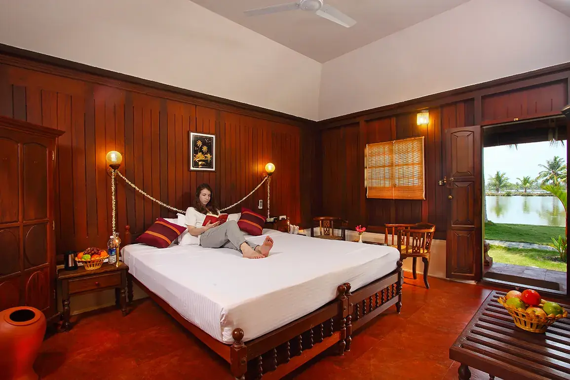Guest relaxing in a Super Deluxe Cottage with a window onto the backwater